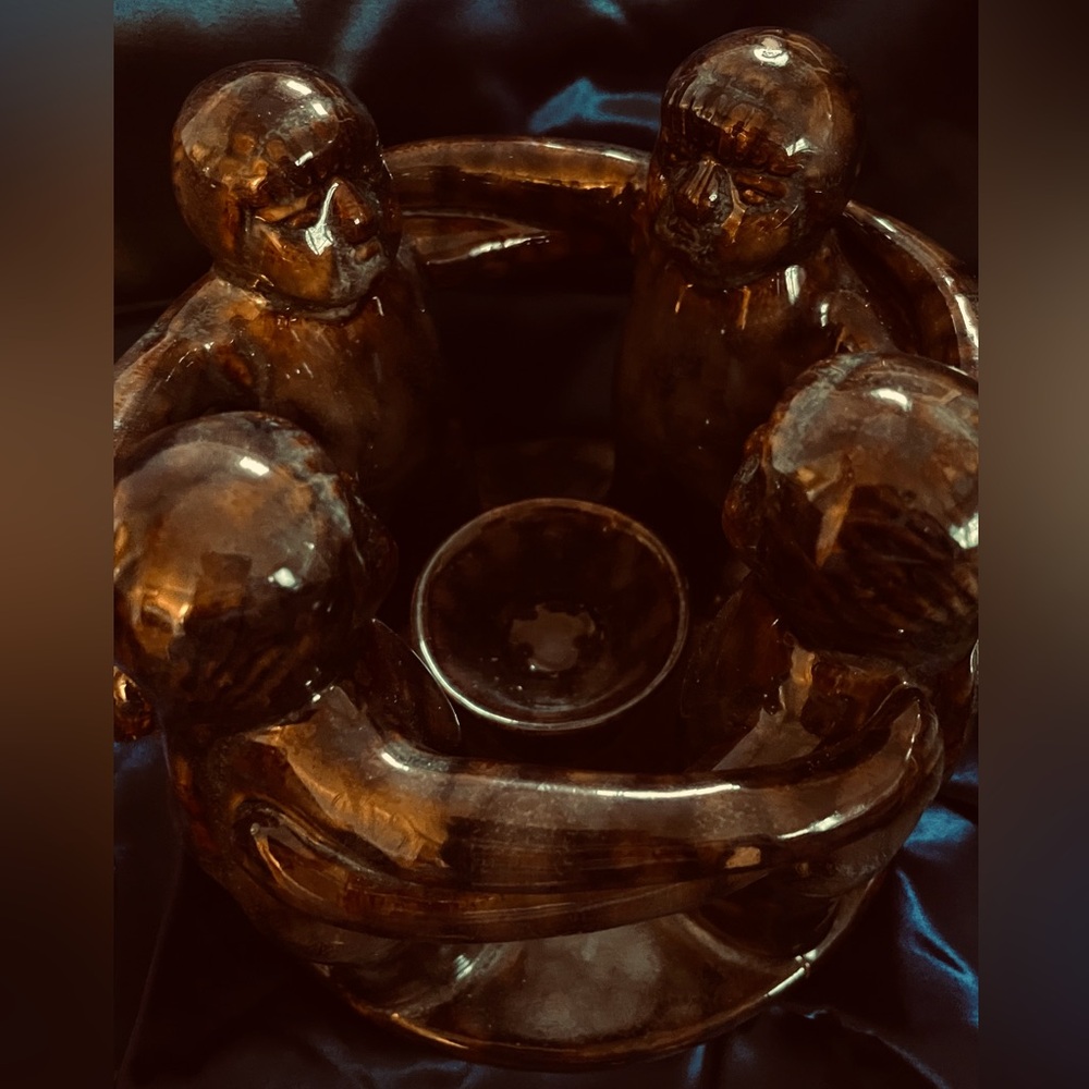 Ceramic central candle holder surrounded by women.